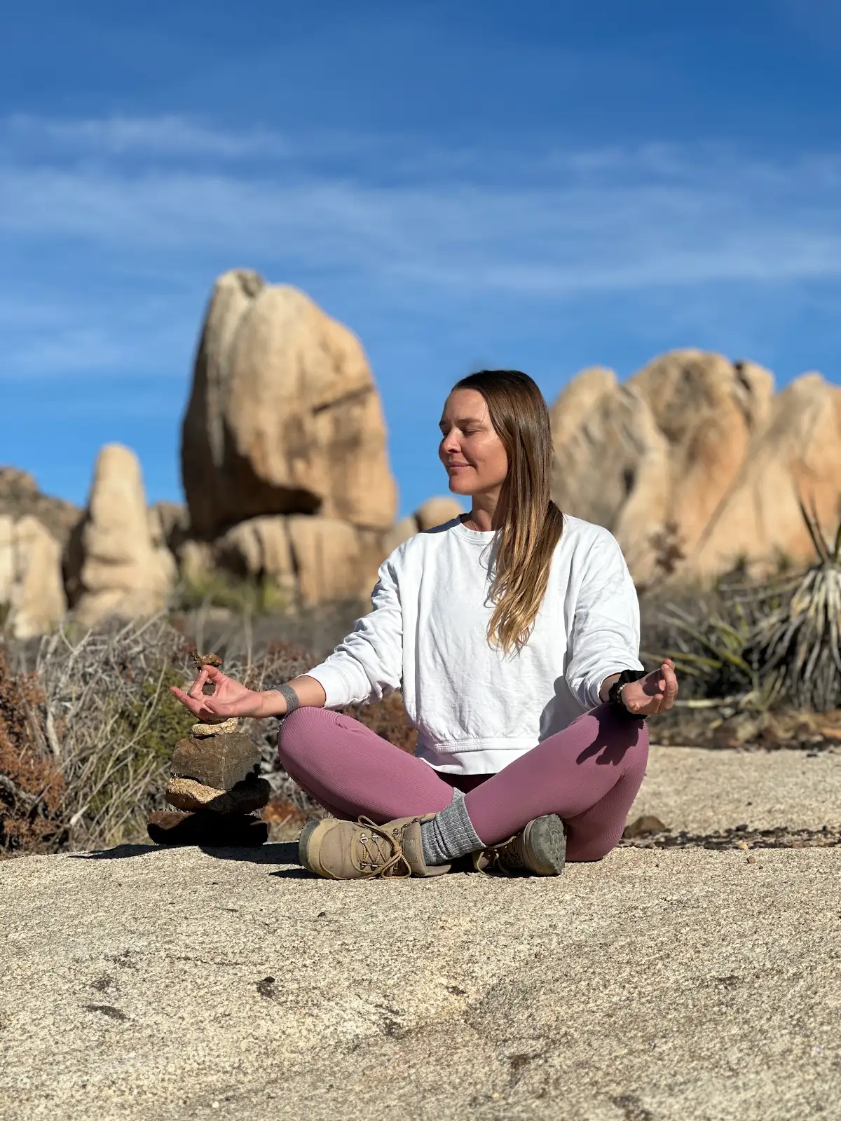Michelle meditating among desert rock formations