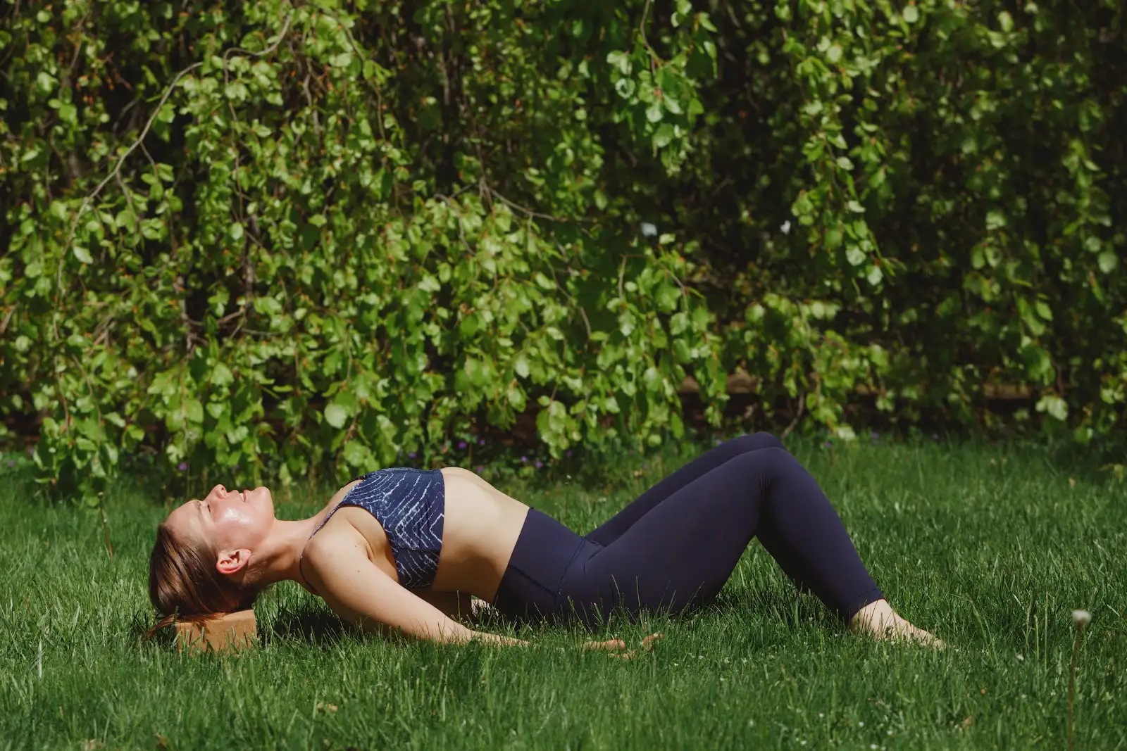 Michelle resting in a supported yoga pose outdoors